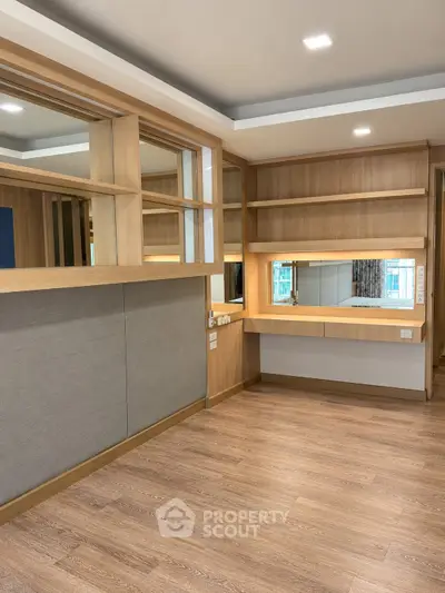 Spacious modern study room with wooden flooring and built-in shelves, perfect for productivity.