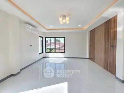 Spacious modern living room with large windows and elegant lighting in a stylish home.