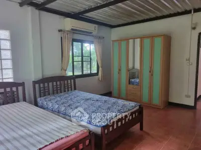 Spacious bedroom with twin beds and large wardrobe, featuring natural light and air conditioning.