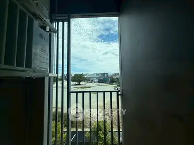Scenic view from a balcony with clear skies and urban landscape.
