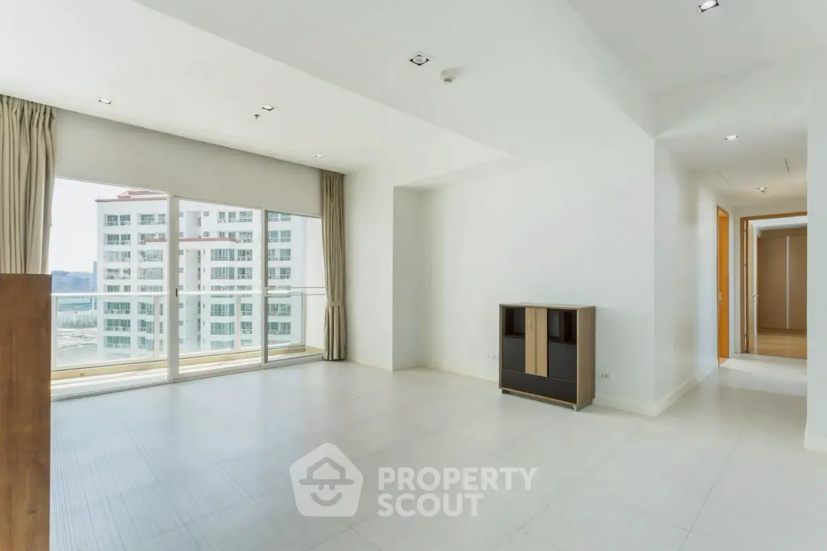 Spacious modern living room with large windows and city view in luxury apartment.