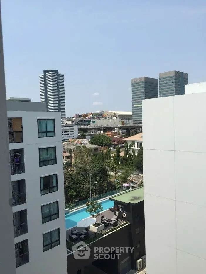 Stunning urban view with modern buildings and a refreshing pool in the foreground.