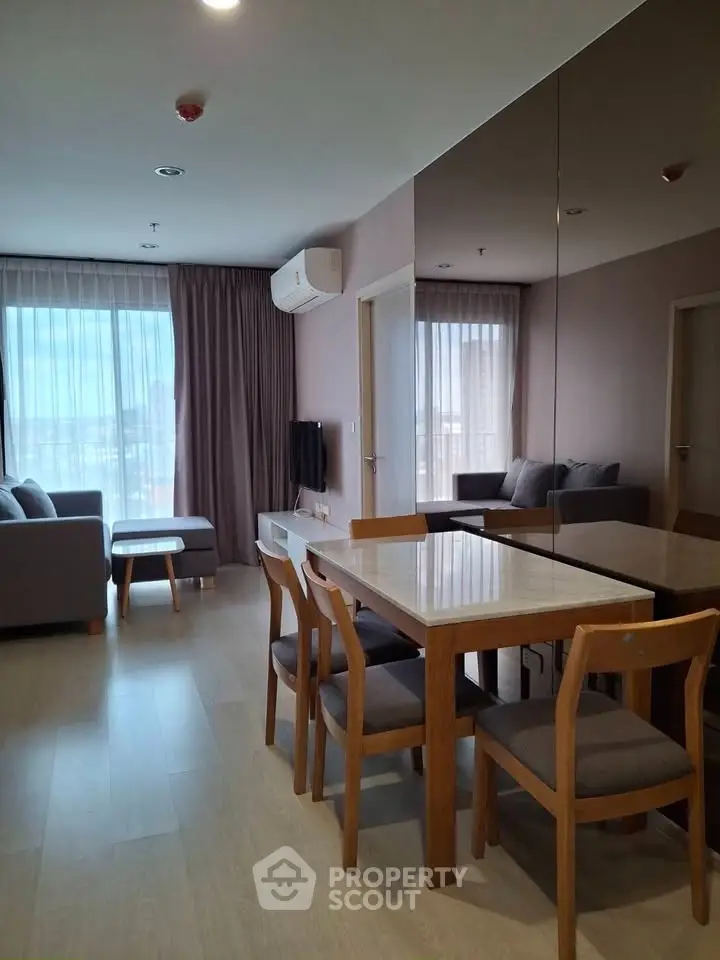 Modern living room with dining area and large windows in a stylish apartment.