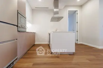 Modern kitchen with sleek cabinetry and hardwood floors in a contemporary apartment.