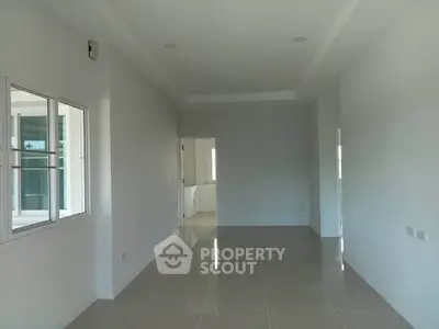 Spacious unfurnished room with large window and glossy tiled floor