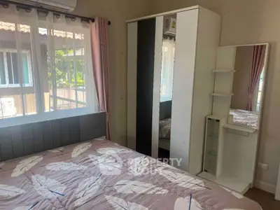 Cozy bedroom with large window and stylish wardrobe, perfect for relaxation.