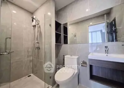 Modern bathroom with glass shower and sleek fixtures in a contemporary apartment.