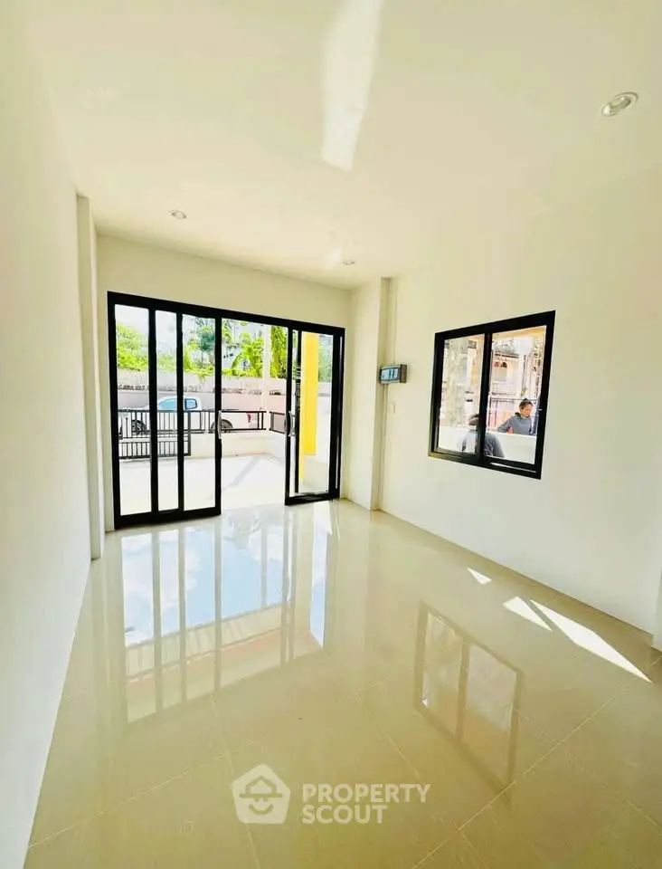 Bright and spacious room with large windows and glossy tiled floor, perfect for modern living.