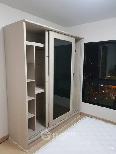 Modern bedroom with sleek wardrobe and city view window