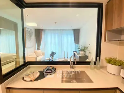 Modern kitchen with open layout and view into stylish living room