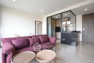 Modern living room with open kitchen and stylish furniture in a contemporary apartment.