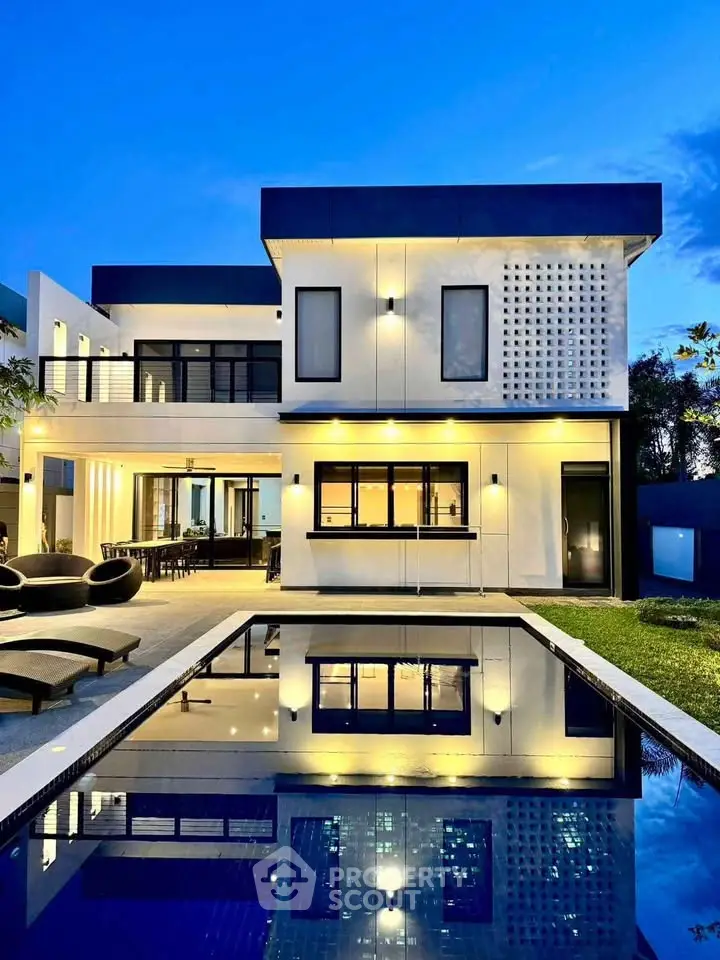 Stunning modern home with pool and elegant outdoor lighting at dusk.