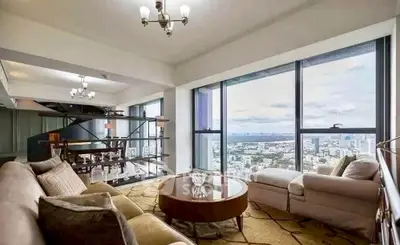 Luxurious living room with panoramic city view and elegant furnishings.