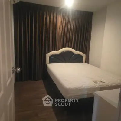 Cozy bedroom with elegant bed and floor-to-ceiling curtains, perfect for restful nights.