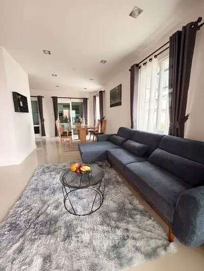 Spacious modern living room with plush gray sofa and elegant dining area.