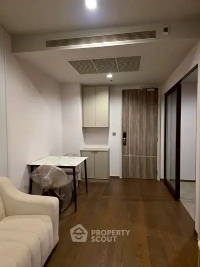 Modern apartment interior with sleek wooden flooring and cozy seating area.