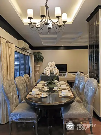 Elegant dining room with chandelier and stylish table setting in luxurious home