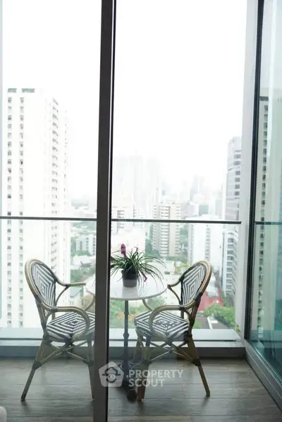 Stunning city view from a modern balcony with stylish outdoor seating.