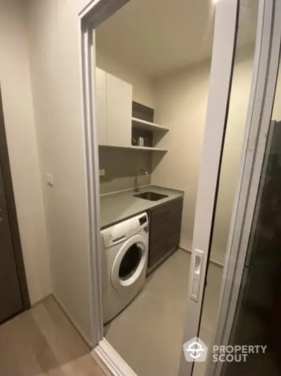 Modern laundry room with washing machine and sleek cabinetry