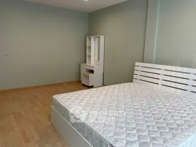 Spacious bedroom with modern furniture and hardwood floors