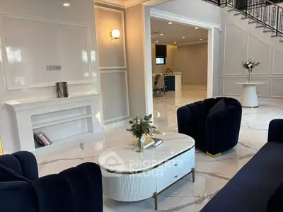 Luxurious living room with elegant navy sofas and marble flooring in a modern home.