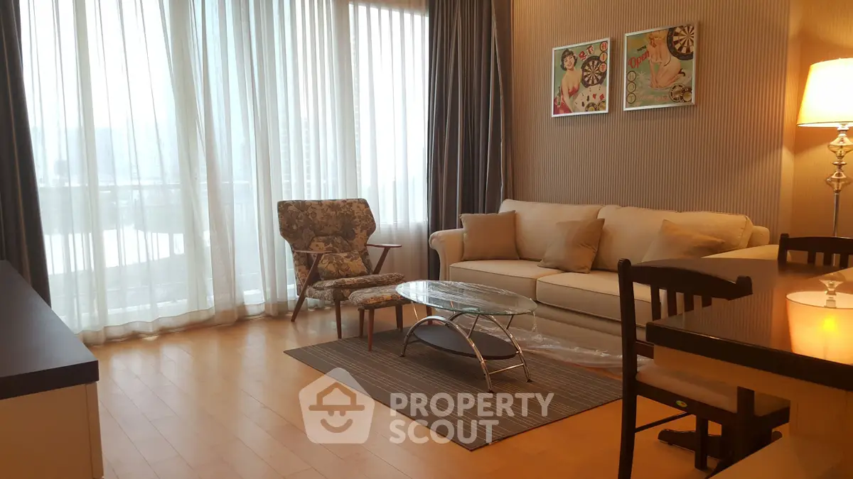 Elegant living room with floor-to-ceiling windows, stylish furniture, and warm lighting.