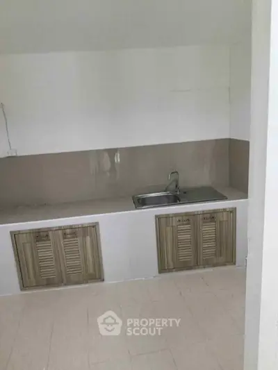 Minimalist kitchen with closed layout and modern sink, ideal for compact living spaces.