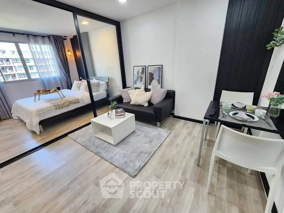 Modern studio apartment with open living area and cozy bedroom, featuring stylish decor and natural light.