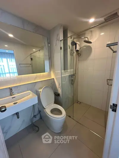 Modern bathroom with glass shower and sleek fixtures in a contemporary apartment.