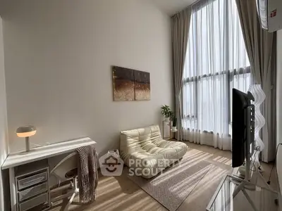 Modern living room with high ceilings, large windows, and stylish furniture in a bright, airy space.