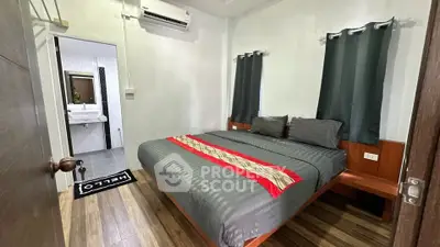 Cozy bedroom with ensuite bathroom, featuring modern decor and air conditioning, perfect for comfortable living.