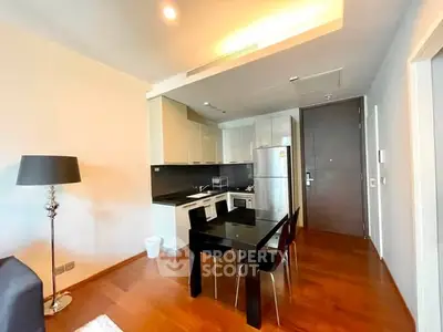 Modern open-layout kitchen with sleek appliances and dining area in stylish apartment.