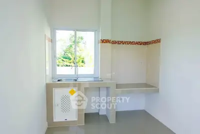 Bright minimalist kitchen with window and tiled backsplash
