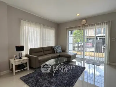 Modern living room with sleek furniture and large windows offering natural light.