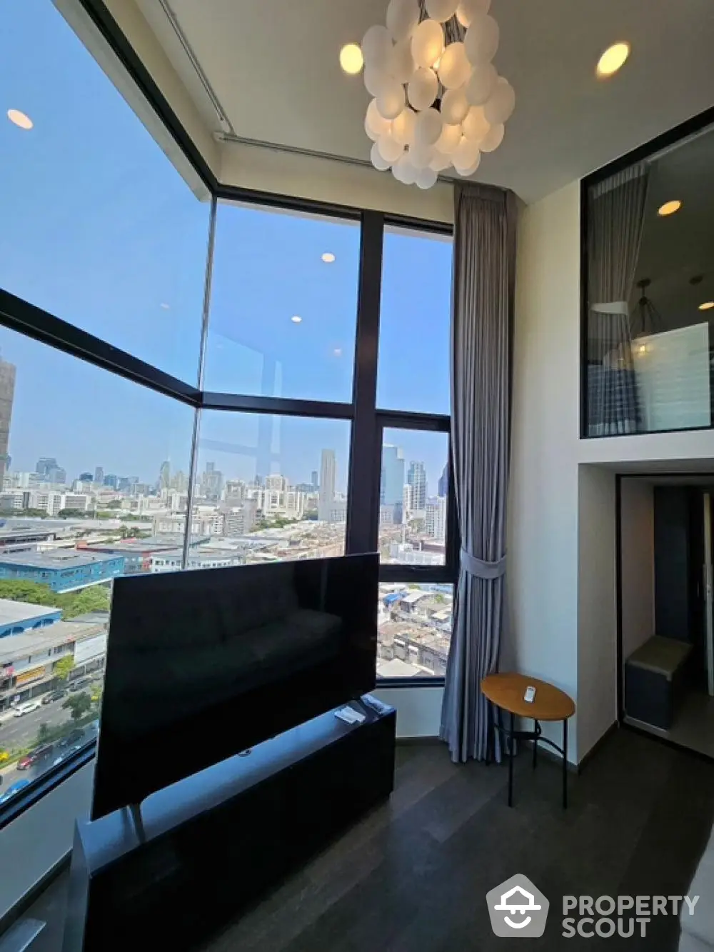 Modern high-rise living room with panoramic city views and stylish decor.