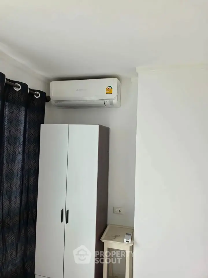 Modern bedroom with air conditioning and sleek wardrobe design.