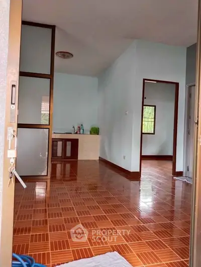 Spacious interior with tiled flooring and natural light, ideal for versatile living space.