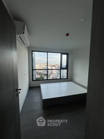 Modern bedroom with large window offering city view and minimalist design