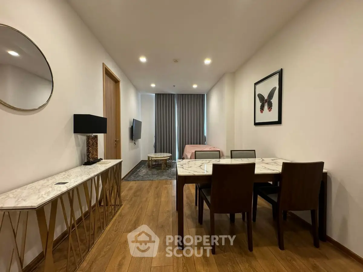 Modern dining area with elegant decor and wooden flooring in a stylish apartment.