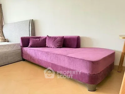 Stylish modern bedroom with plush purple sofa and elegant bed frame