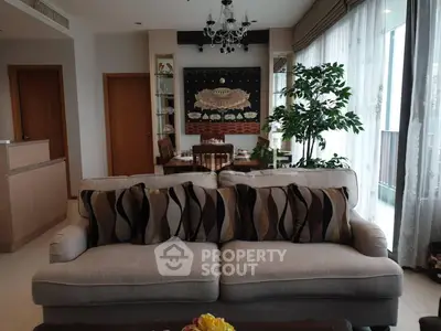Elegant living room with plush sofa, dining area, and large windows for natural light.