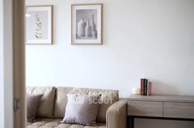 Stylish living room with beige sofa, modern art, and sleek console table.