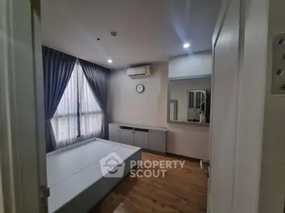 Spacious bedroom with modern design, featuring large windows and elegant curtains, perfect for relaxation.