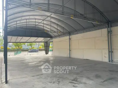 Spacious industrial-style covered parking area with durable metal roof and open sides.