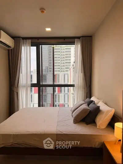 Cozy bedroom with large window and modern decor in urban apartment