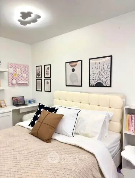 Cozy bedroom with stylish decor and modern artwork on walls.