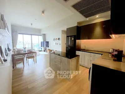 Modern open-layout kitchen and living room with stylish decor and natural light.
