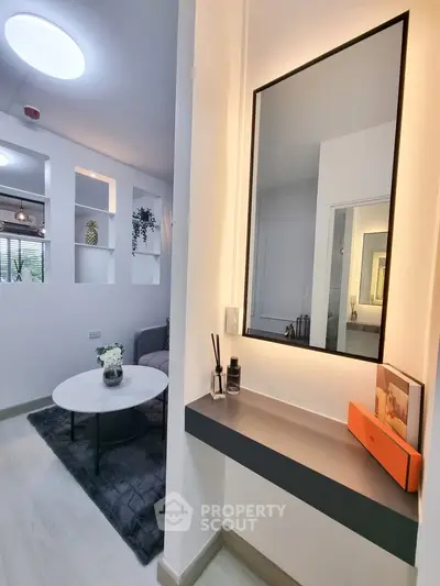 Modern living room with stylish decor and large mirror, perfect for contemporary living.