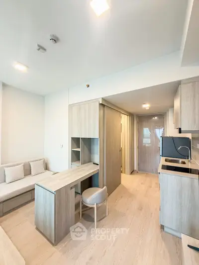 Modern living room with sleek wooden furniture and open kitchen layout