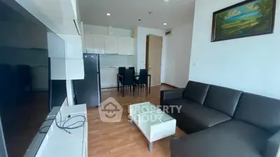 Modern living room with sleek furniture and open kitchen layout in a stylish apartment.